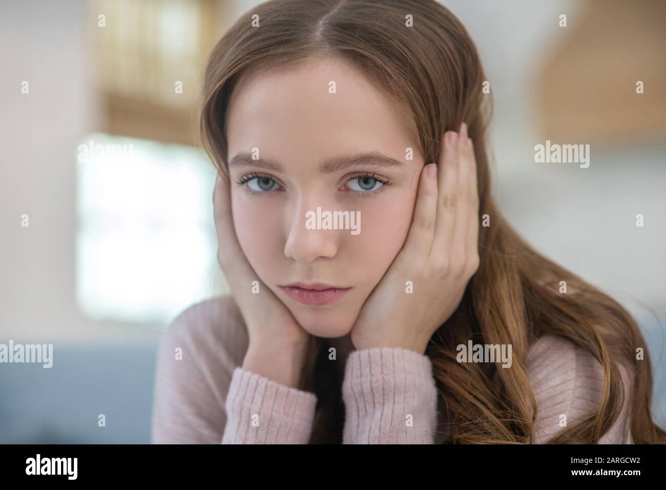 Teen girl face looking sadly in front of herself. Stock Photo