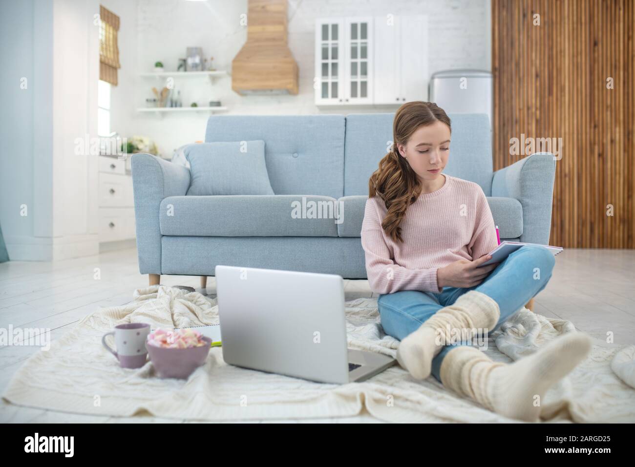Girl sitting on the floor in room and painting in album Stock Photo - Alamy