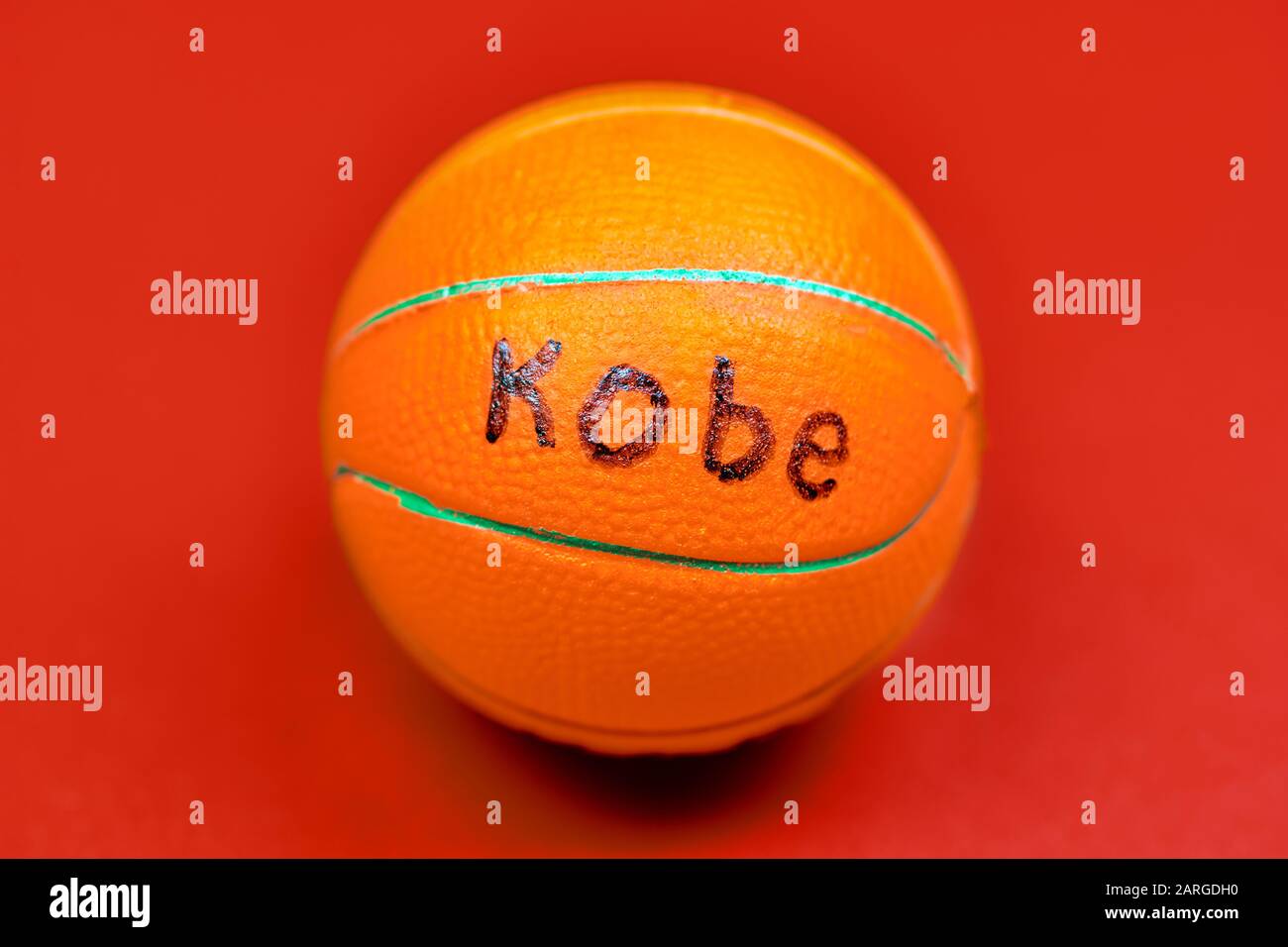 Basketball ball with KOBE text, red background. Famous basketball player concept. Stock Photo