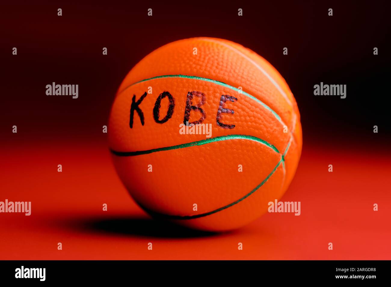 Basketball ball with KOBE text, red background. Famous basketball player concept. Stock Photo