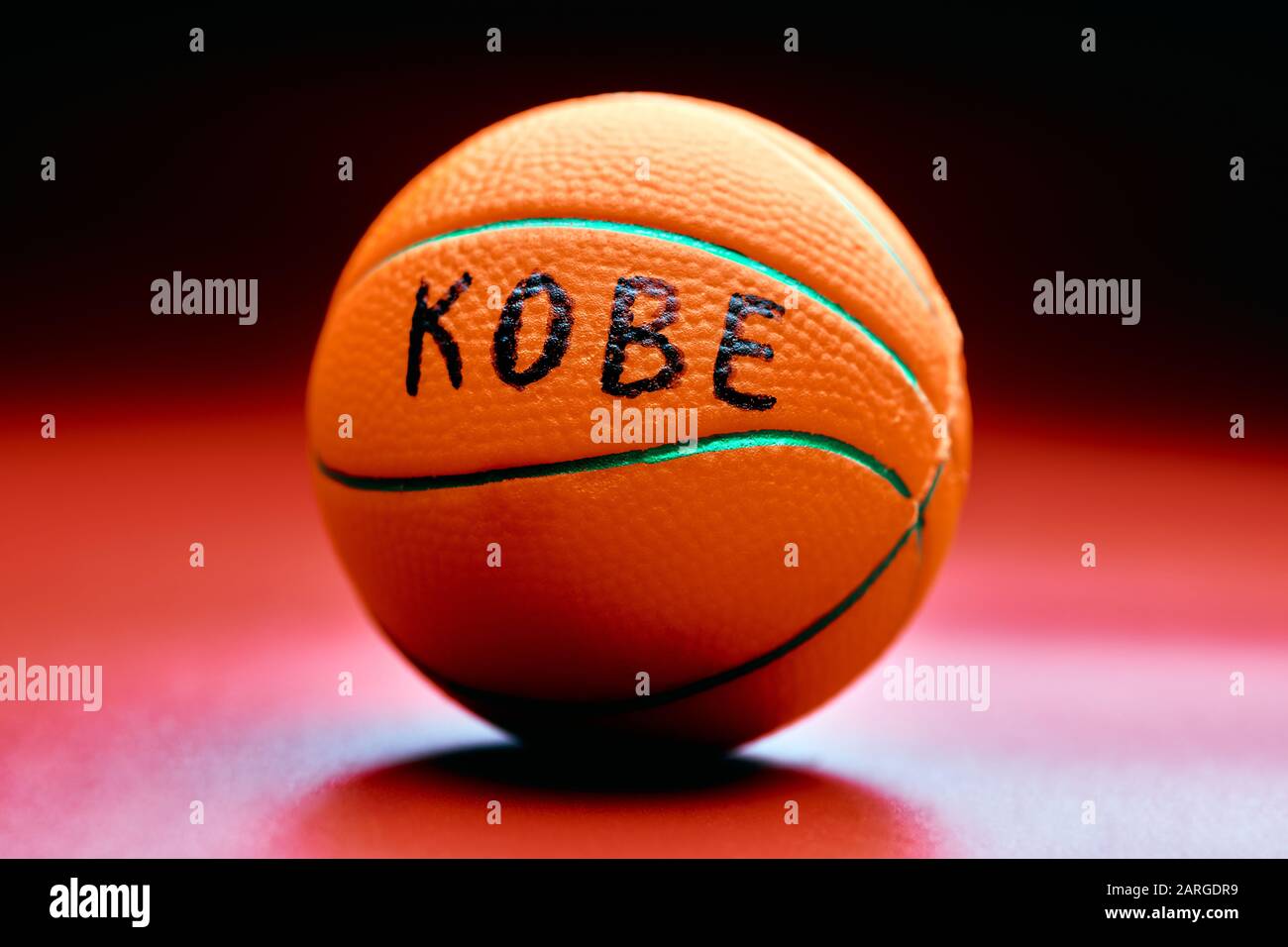 Basketball ball with KOBE text, red background. Famous basketball player concept. Stock Photo