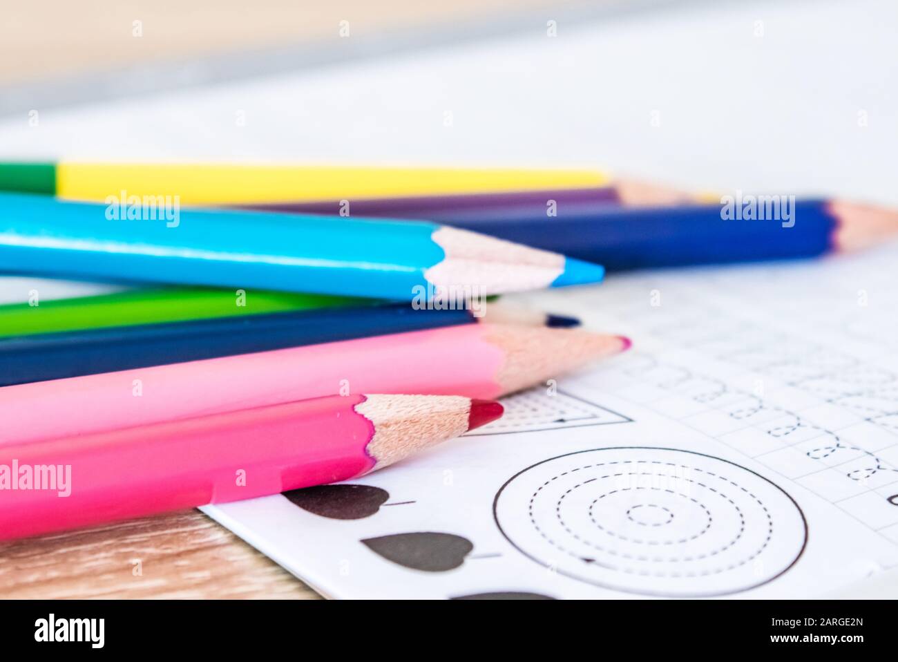 Colored pencils scattered on a school notebook. Close-up. Stock Photo