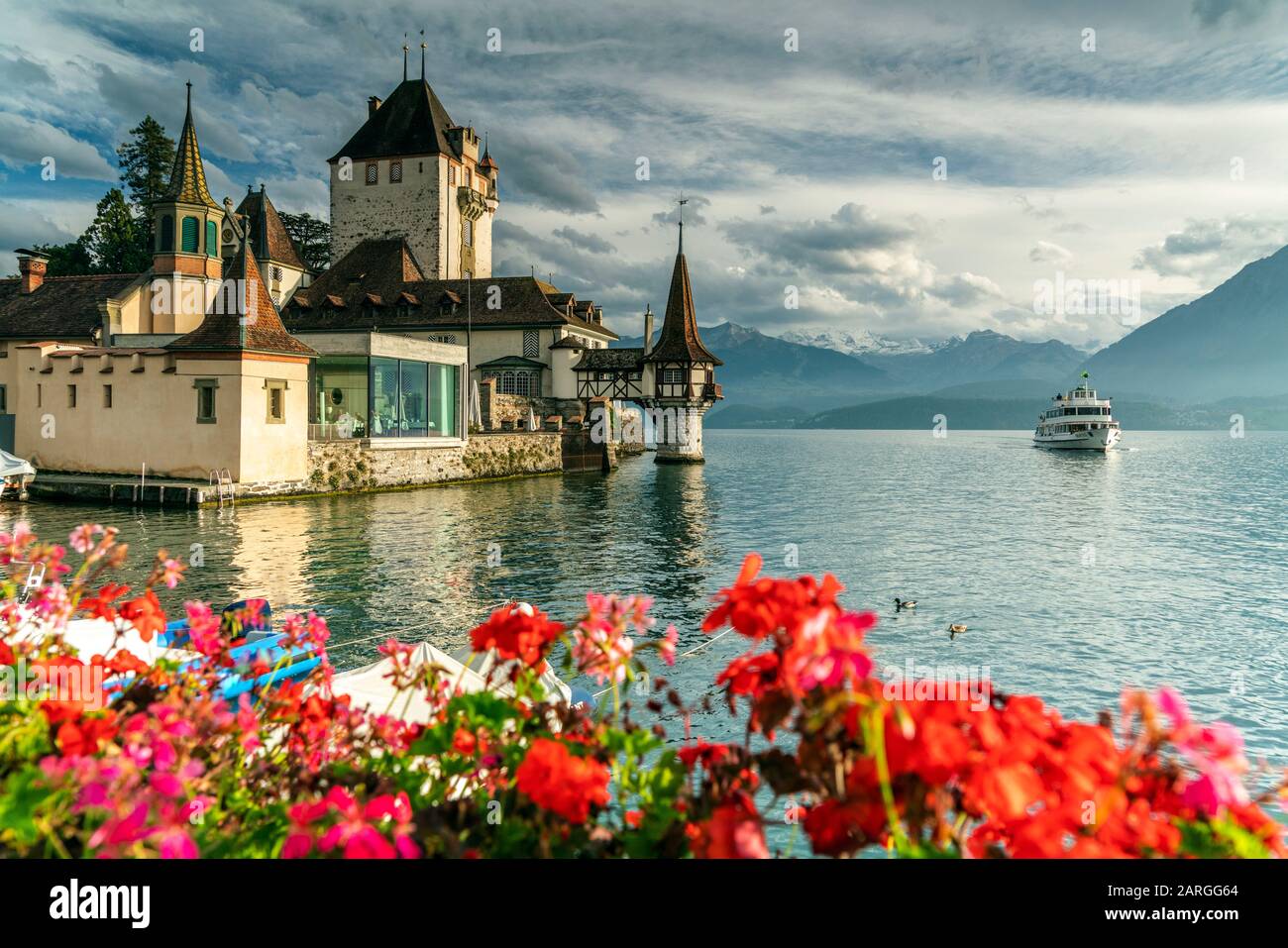 Flowers framing Oberhofen Castle and Lake Thun, Canton of Bern, Switzerland, Europe Stock Photo