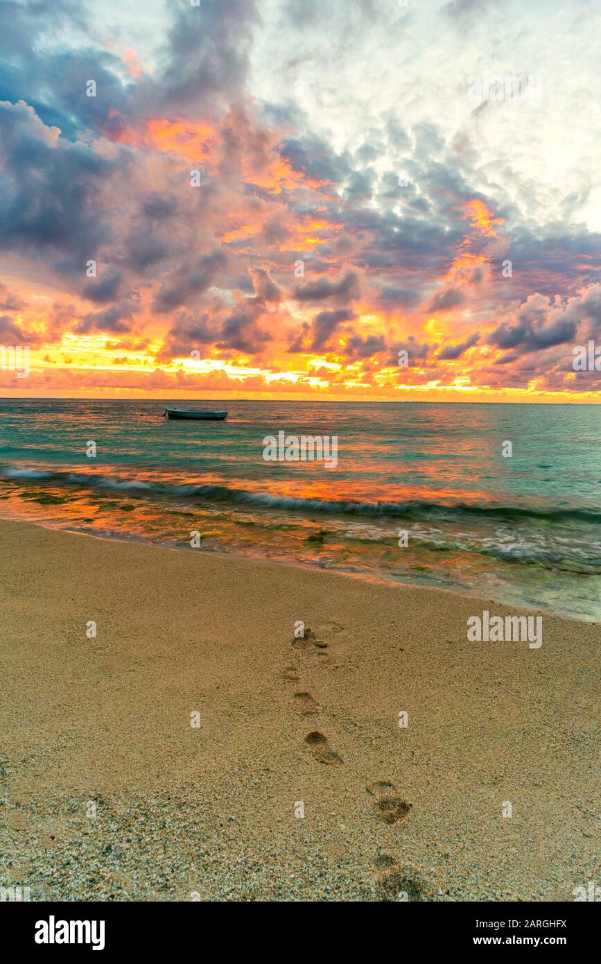 African sunset over footprints on tropical sand beach, Le Morne Brabant, Black River, Mauritius, Indian Ocean, Africa Stock Photo