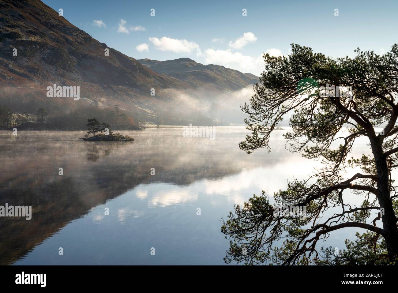 Dawn light and transient sunlit mist over Wall Holm Island on Ullswater, Lake District National Park, UNESCO World Heritage Site, Cumbria, England, UK Stock Photo