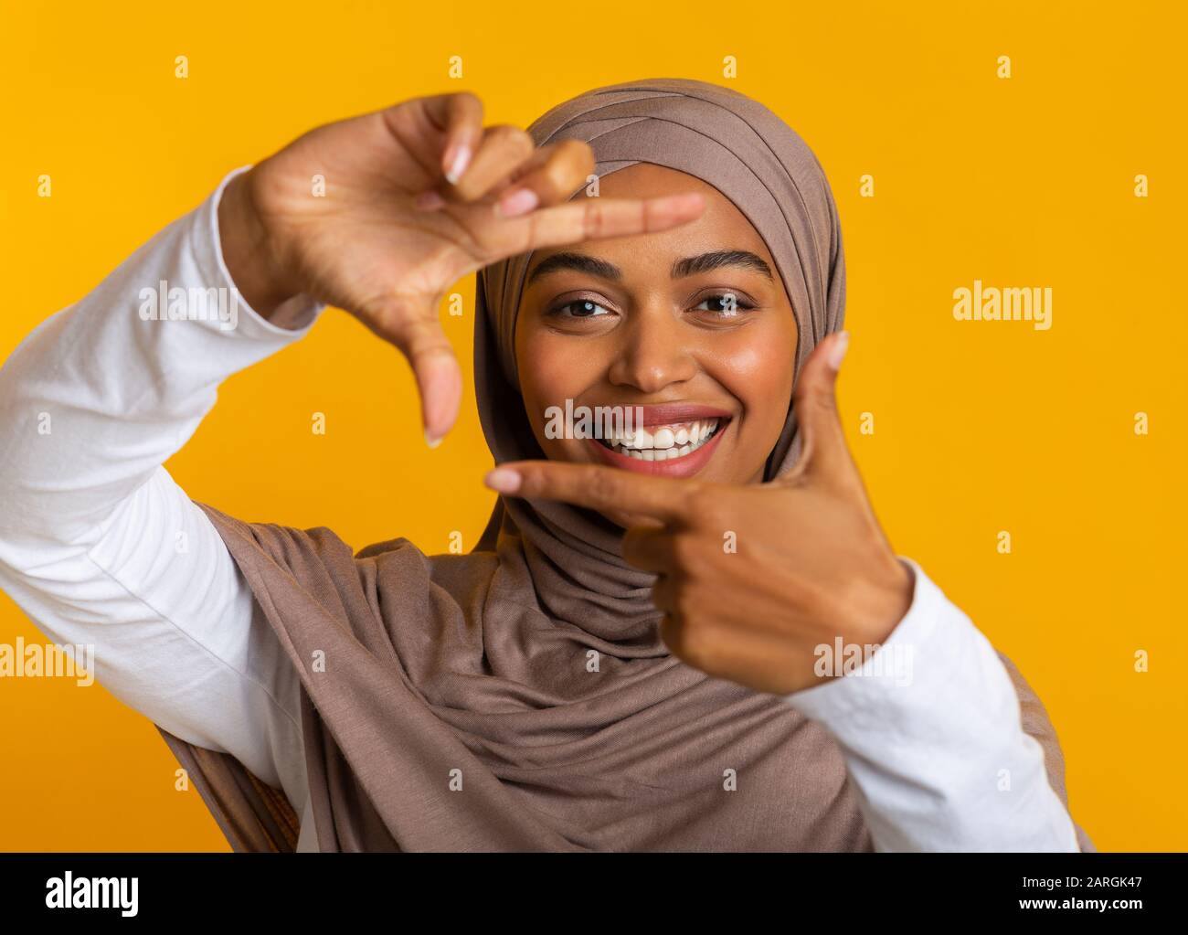 Happy Black Muslim Girl In Headscarf Making Frame With Fingers Stock