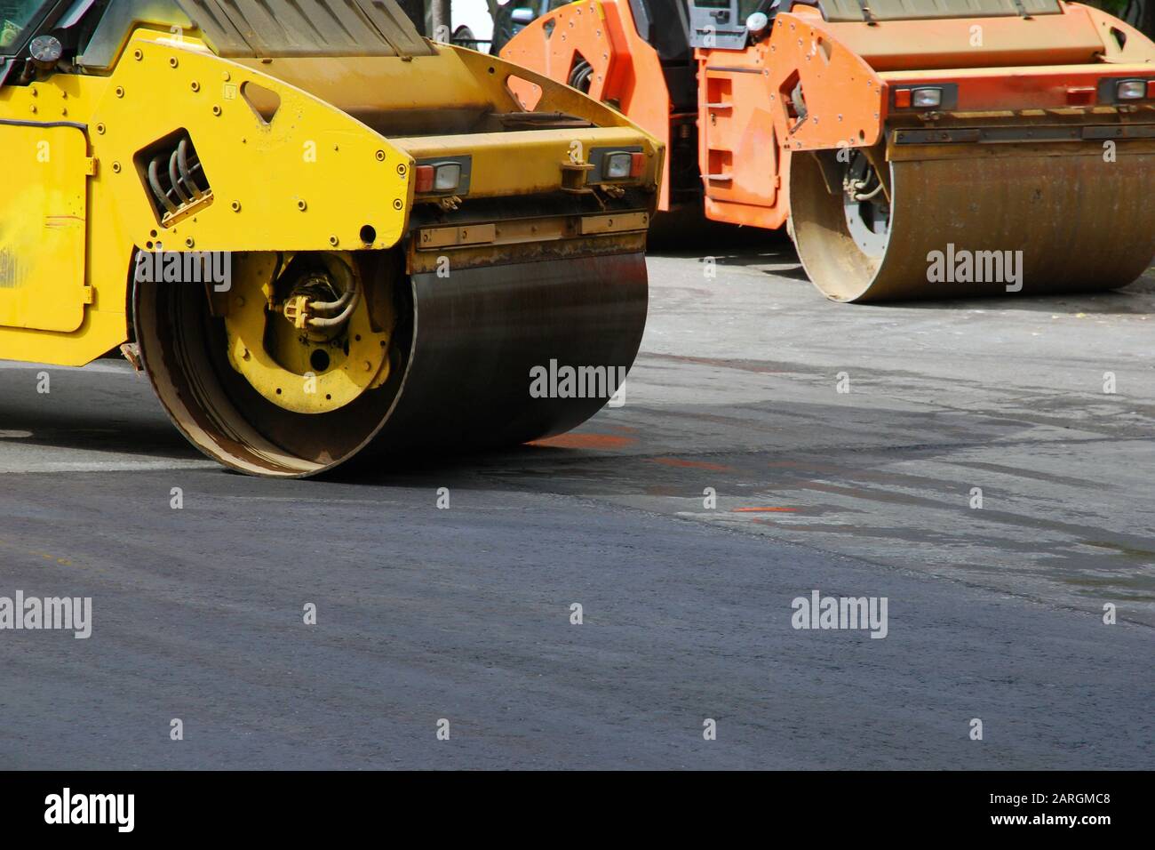 Two asphalt rollers working in the street, no people, selective focus Stock Photo