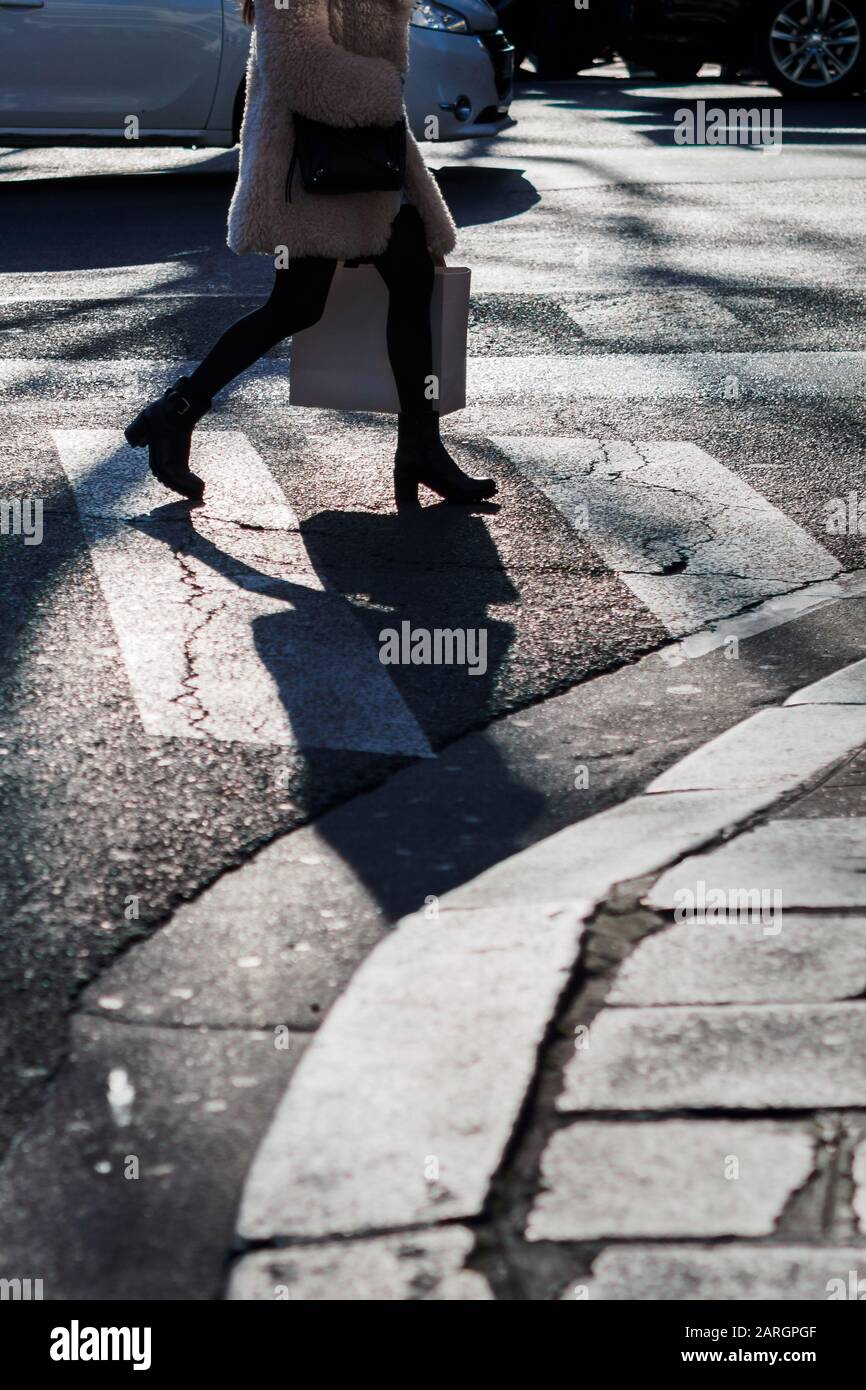 Woman crossing a pedestrian crossing in the Parisian streets Stock Photo