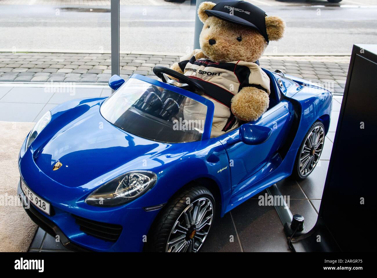 RIGA, LATVIA. 22nd January 2020. Teddy bear toy at Porsche toy car. Porsche is a German automobile manufacturer specializing in high-performance sports cars, SUVs and sedans. Stock Photo