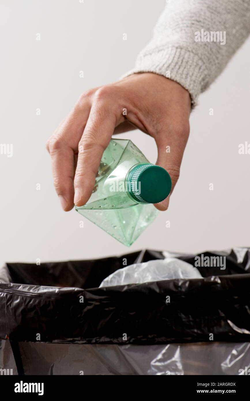 closeup of a young caucasian man about to throw an empty plastic bottle to the trash bin Stock Photo