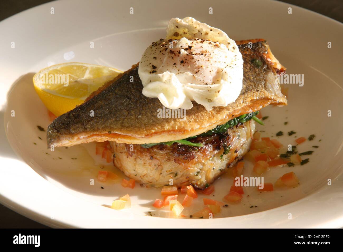 Cooked Sea bass with a poached egg Stock Photo
