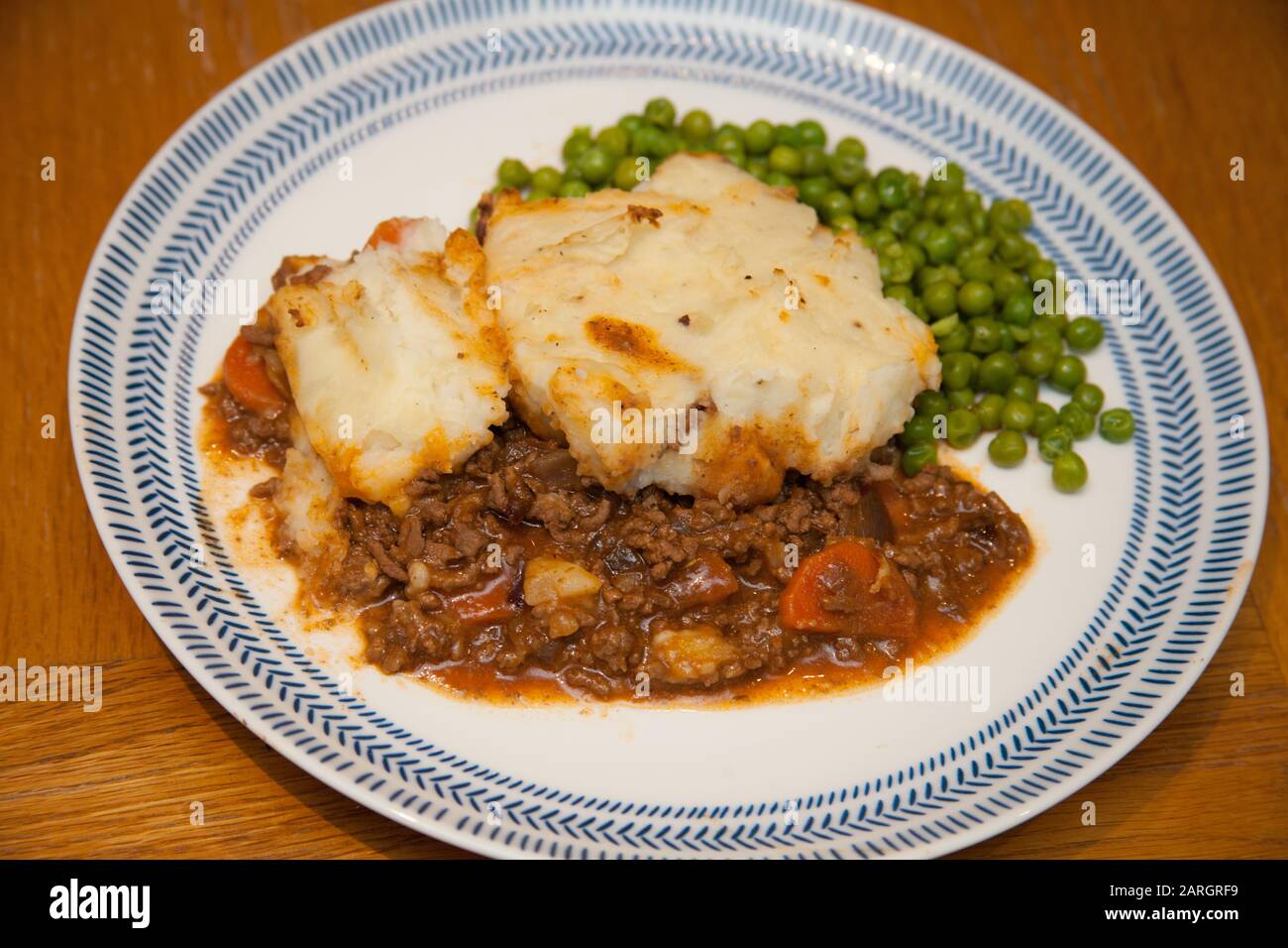 Cottage pie with peas on a plate Stock Photo