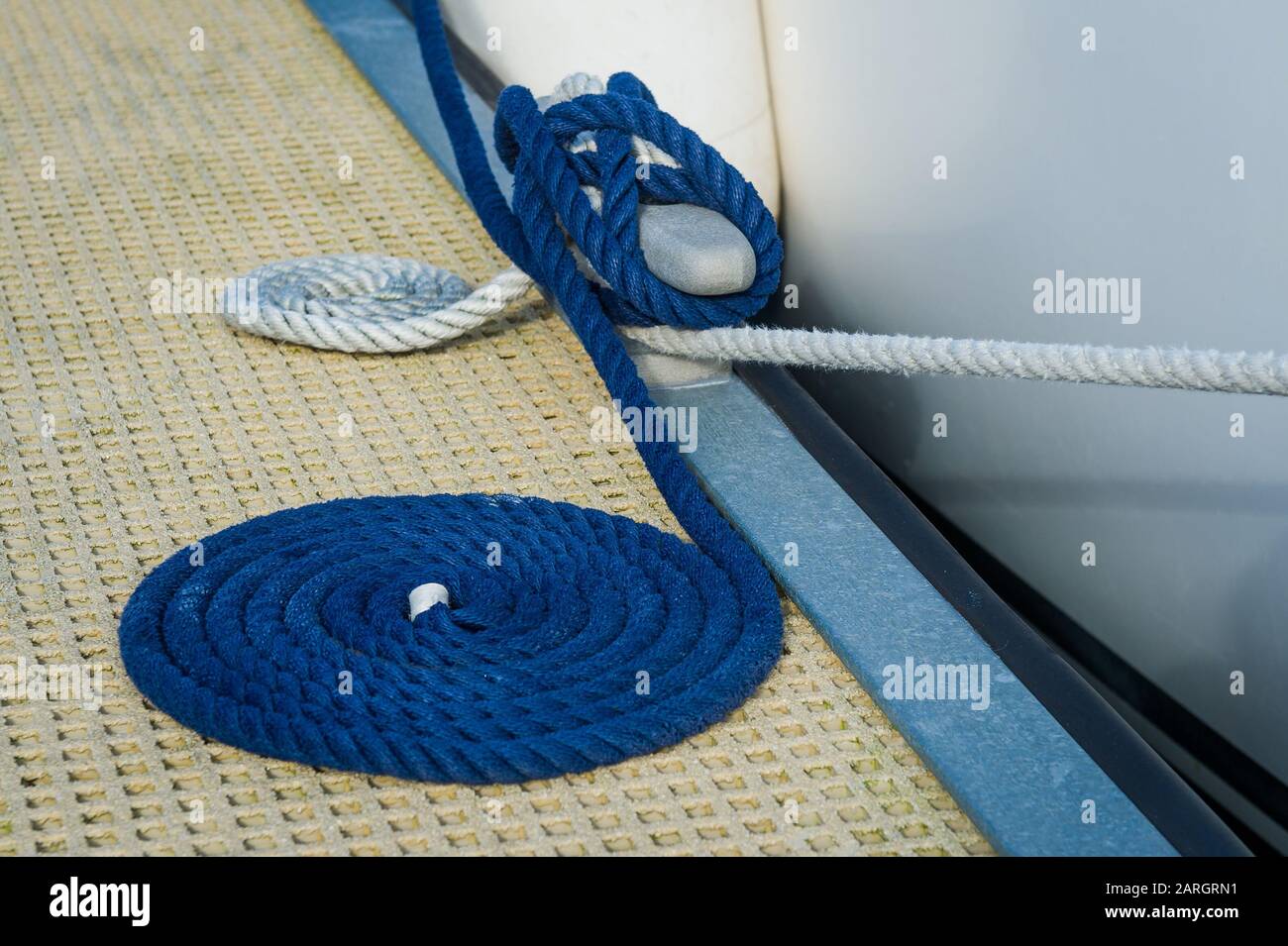 Nice coiled docking lines and pier cleat. Sailing yacht in Oban, Scotland. Stock Photo