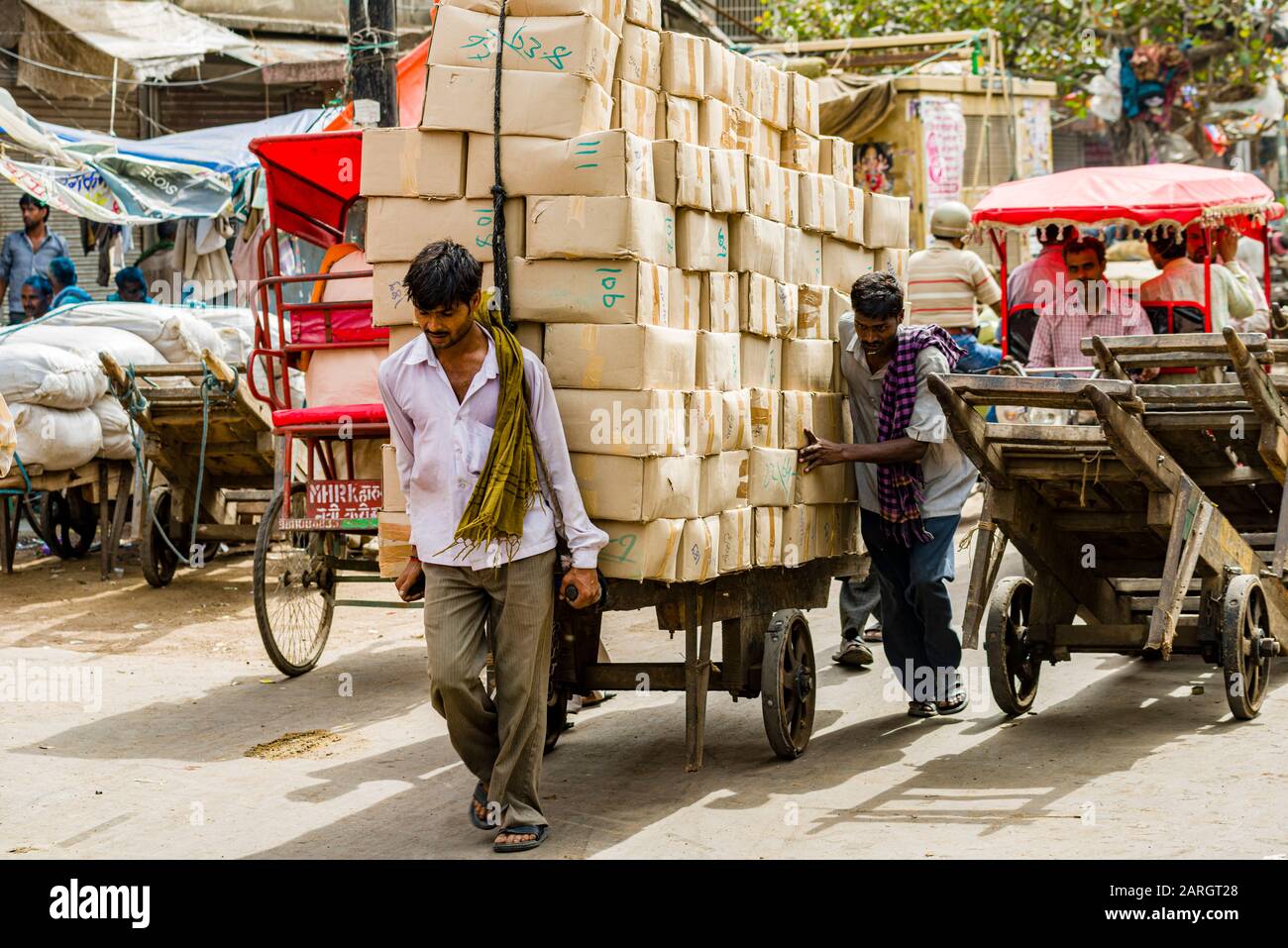 Goods and big loads get transported by human power on carts and cycle rickshaws on Khari Baoli Road in Old Delhi Stock Photo