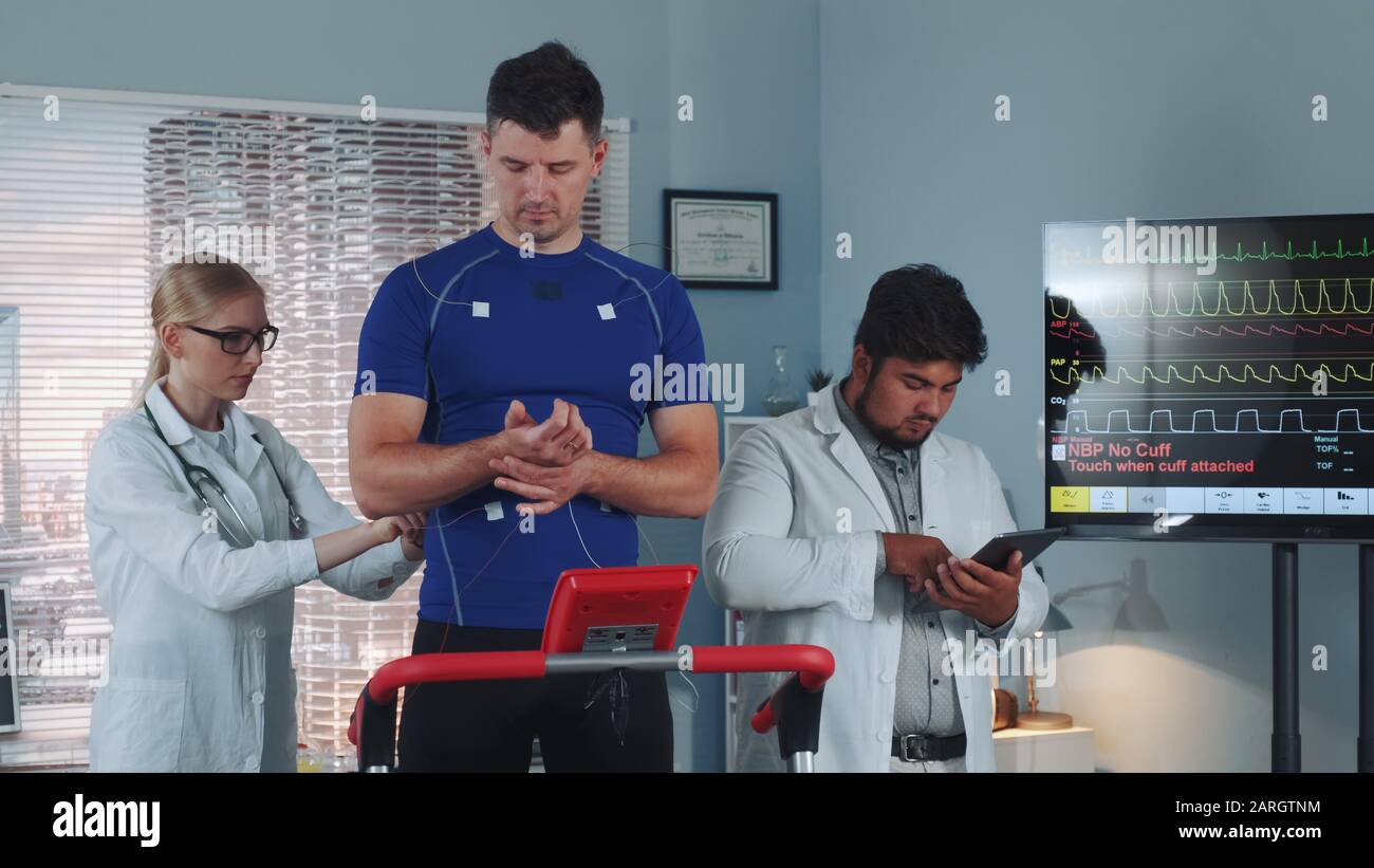 Diverse group of sport scientists monitoring athlete's physical health