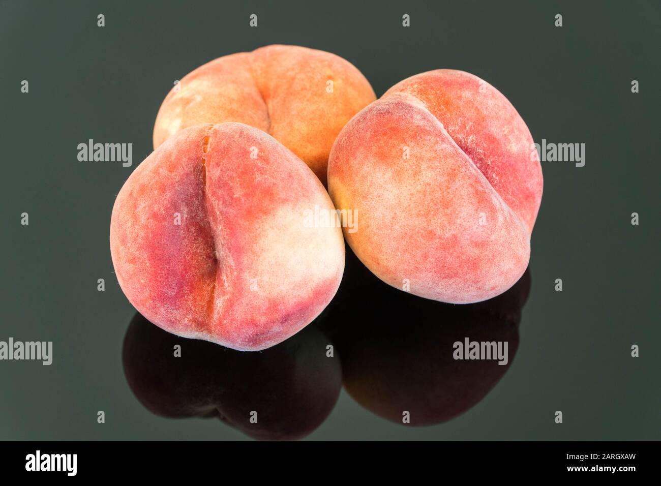 Fresh Peaches on reflective surface. Stock Photo
