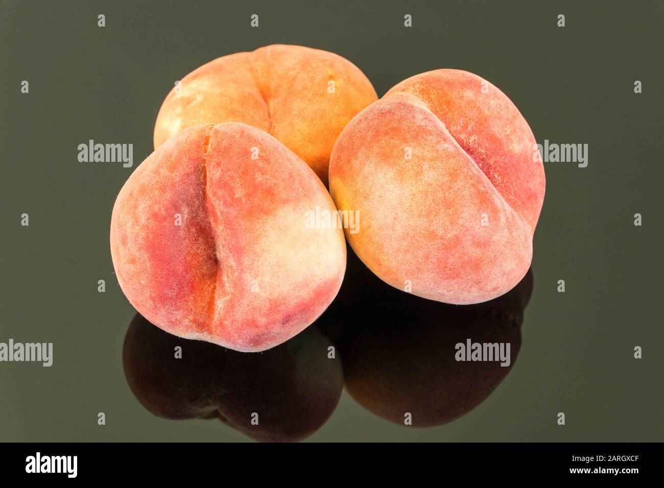 Fresh Peaches on reflective surface. Stock Photo
