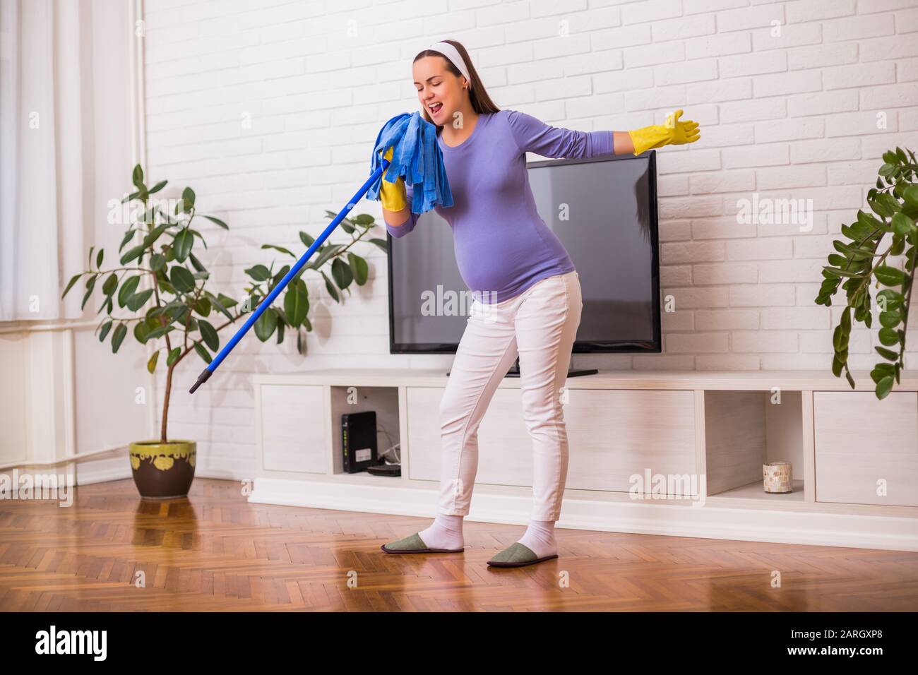Beautiful pregnant woman enjoys cleaning her house Stock Photo Alamy
