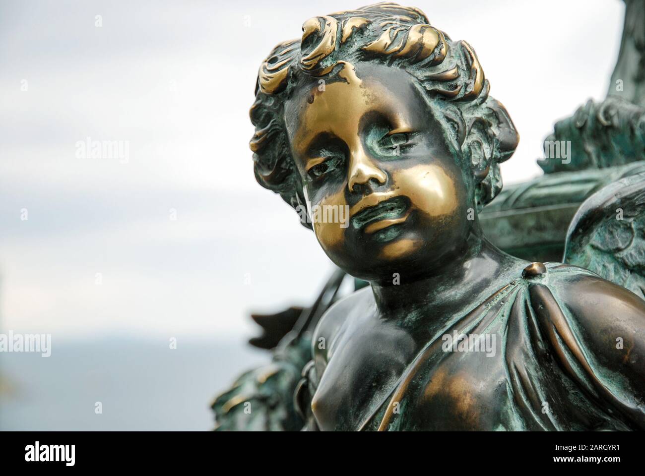 Old oxidized bronze statue of a boy with polished spots on his face as symbol of skin disease, pathology or condition such as vitiligo or psoriasis Stock Photo