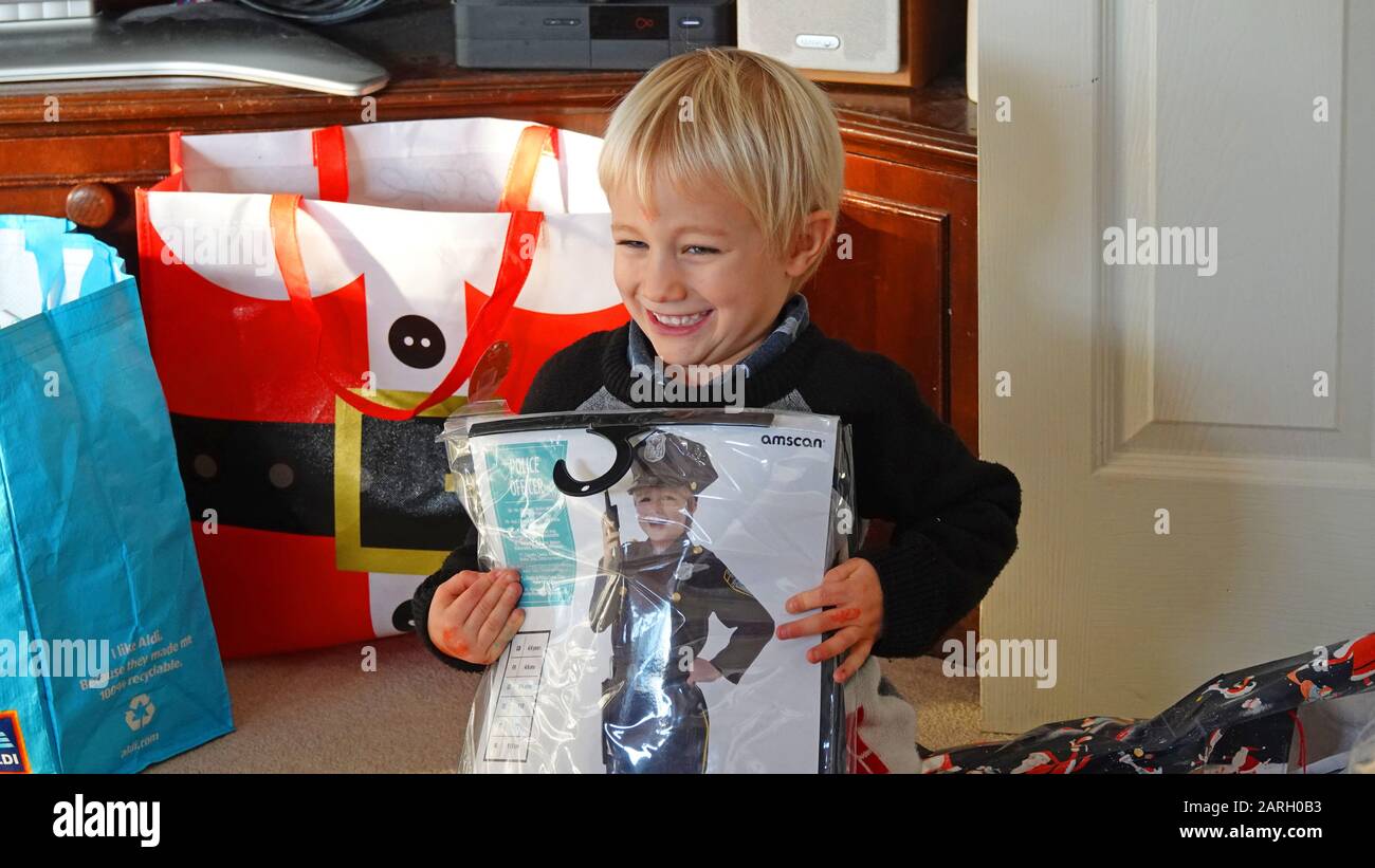 Six Year Old Boy Having Opened Christmas Present, Fancy Dress Police Officer Outfit Stock Photo