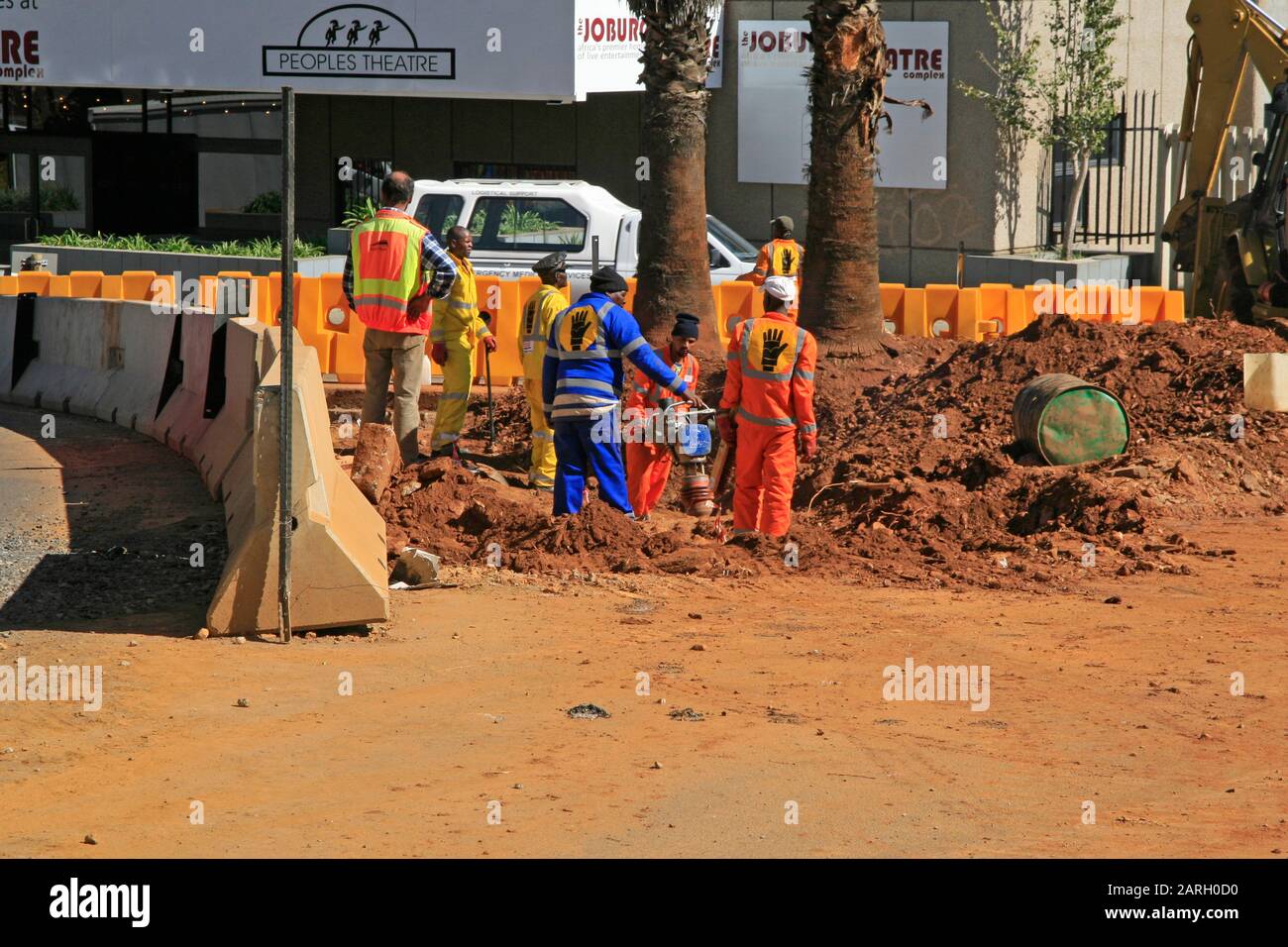 Roadworkers and road traffic safety barriers in front of Joburg Theatre