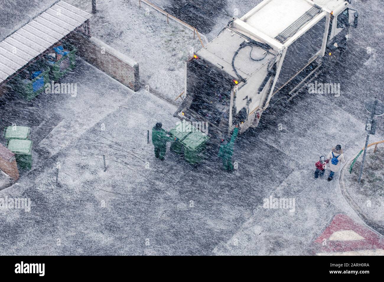 Garbage men in snow storm working in residential area Stock Photo