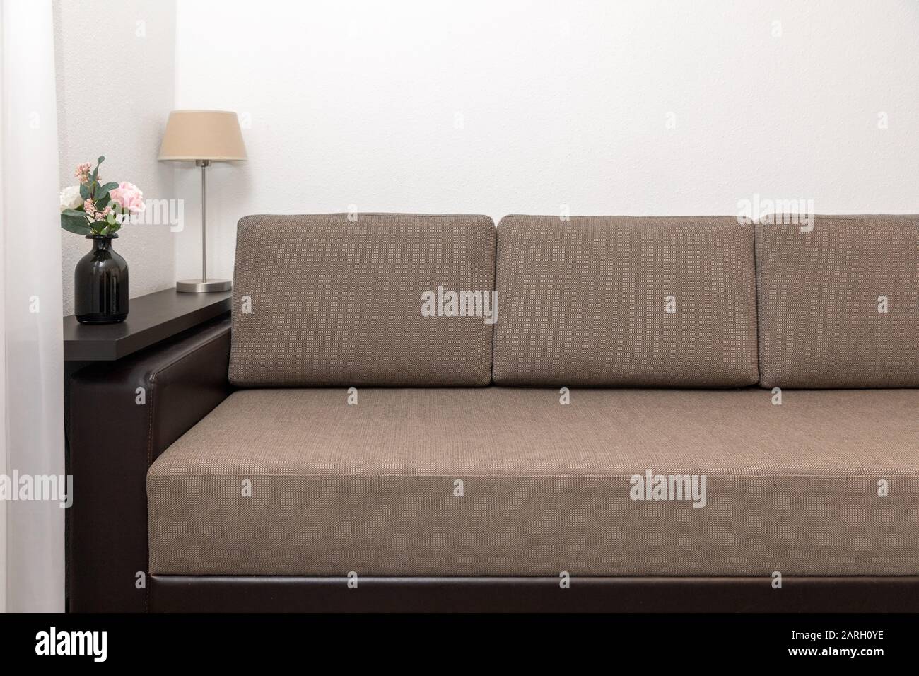 living room interior with brown fabric sofa, wall shelf and decors Stock Photo