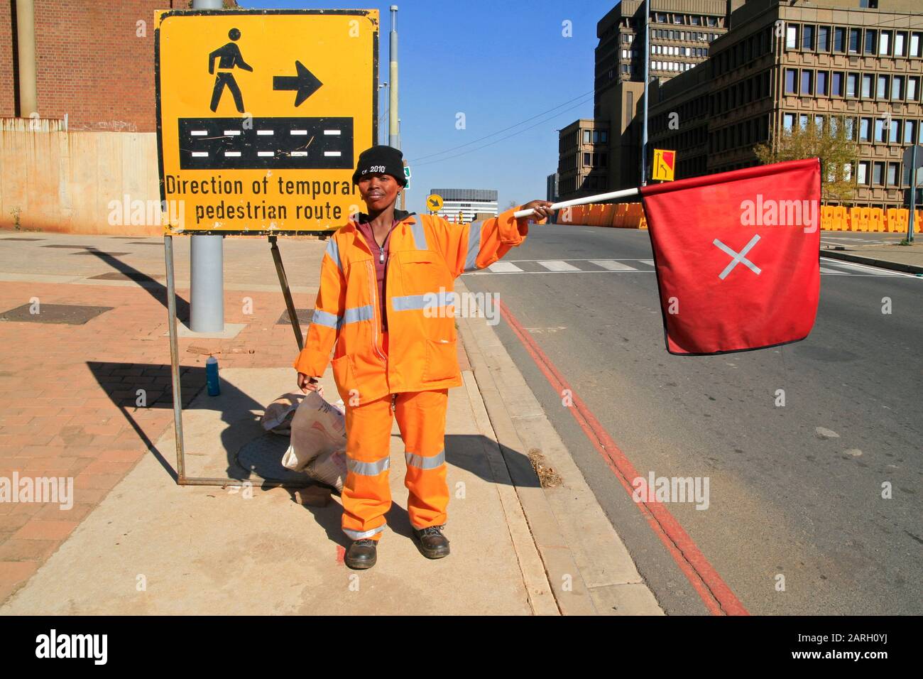 Roadworks and road worker regulating traffic with road traffic safety