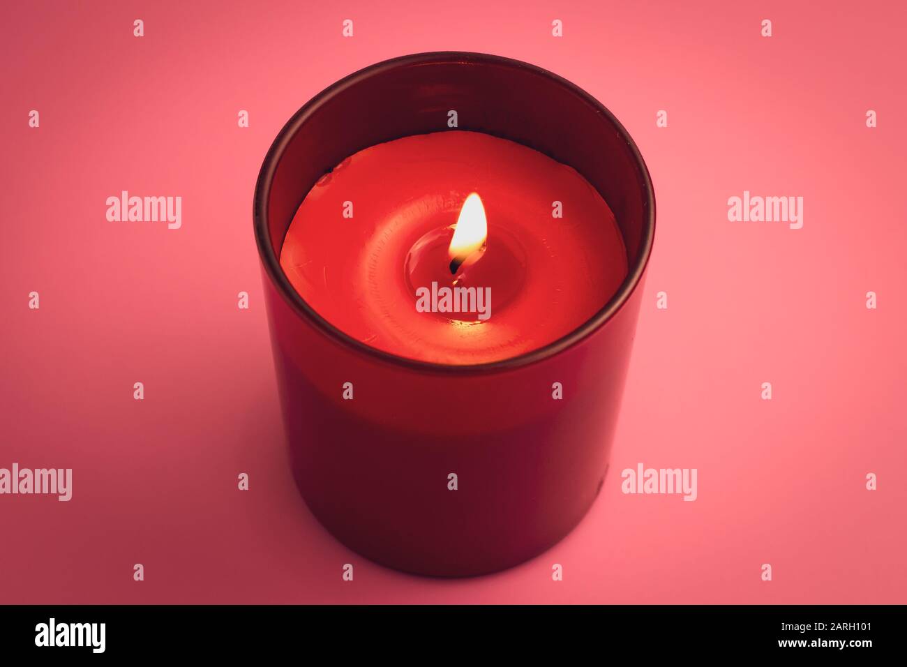 Red candle with flame on pink background. Aromatherapy, relaxation concept Stock Photo
