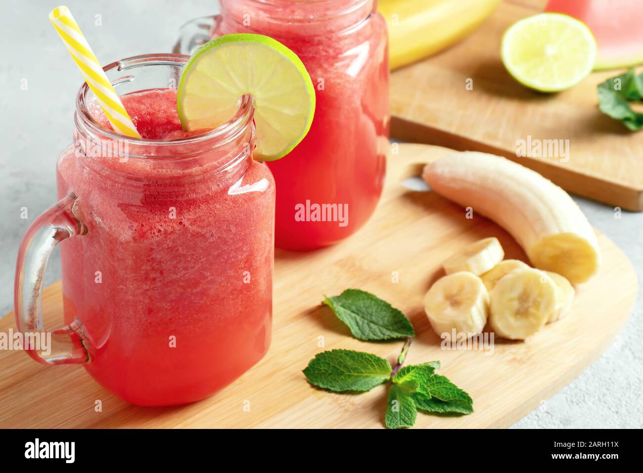 Watermelon smoothie with banana, lime and mint in mug jars on a cutting  board. Healthy eating concept Stock Photo - Alamy