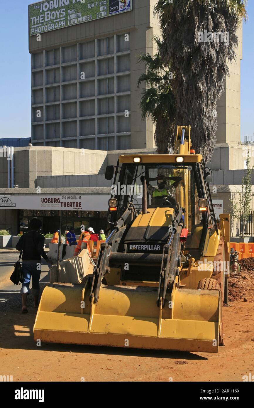 Caterpillar construction tractor with roadworkers and student in front