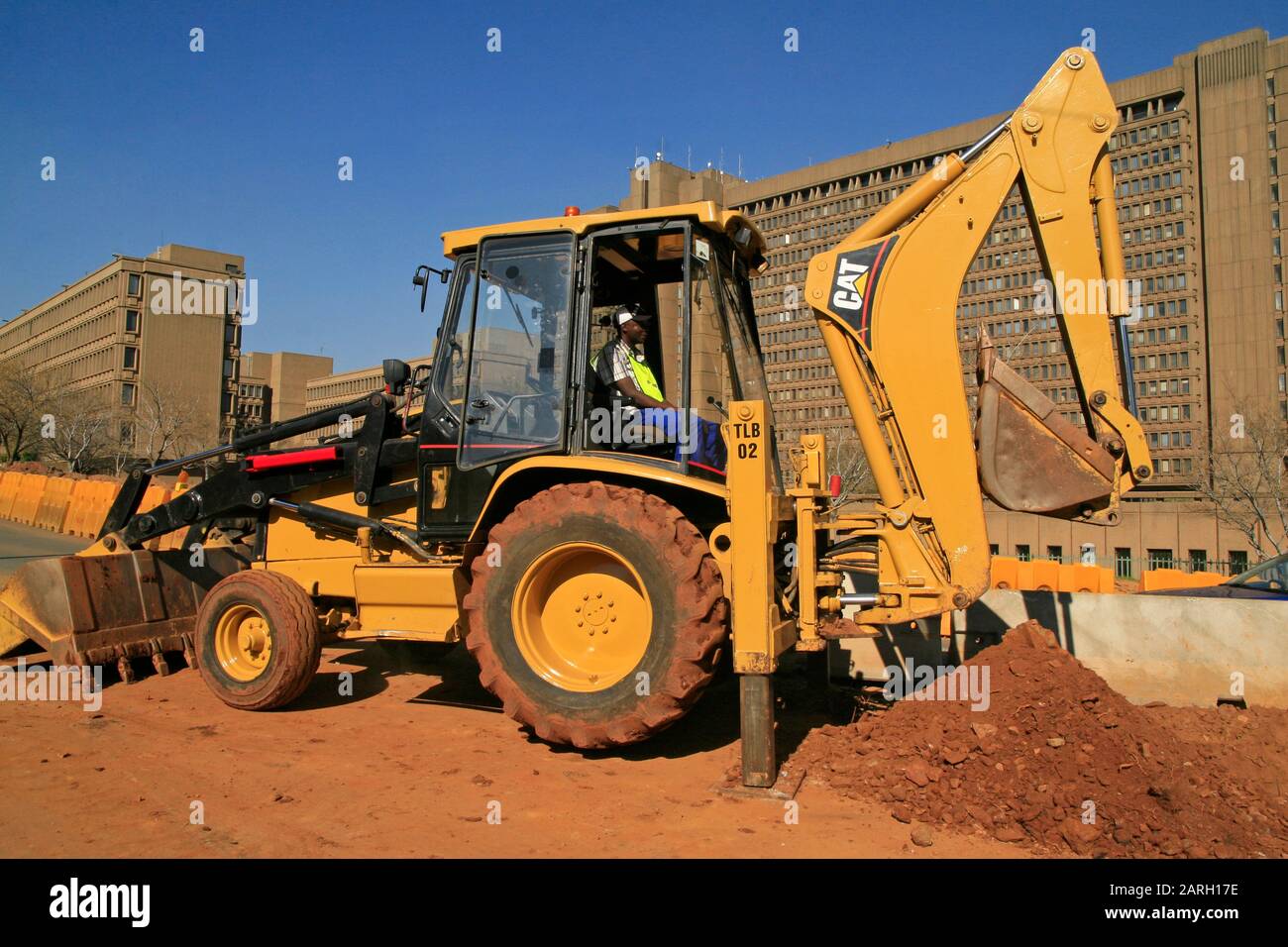 Caterpillar construction tractor with roadworker inside in front of