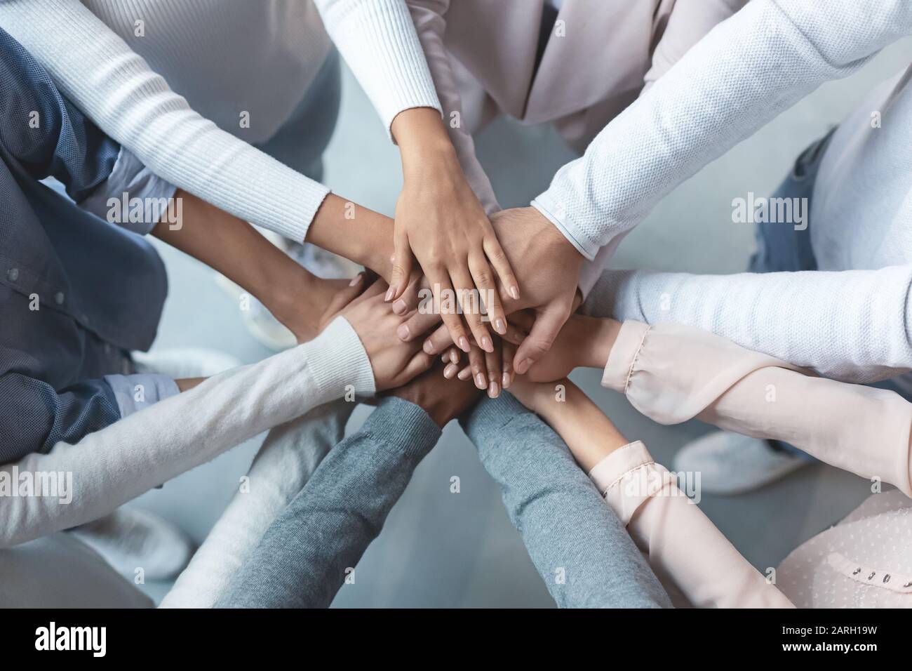 Multiracial business team putting hands on top of each other Stock Photo