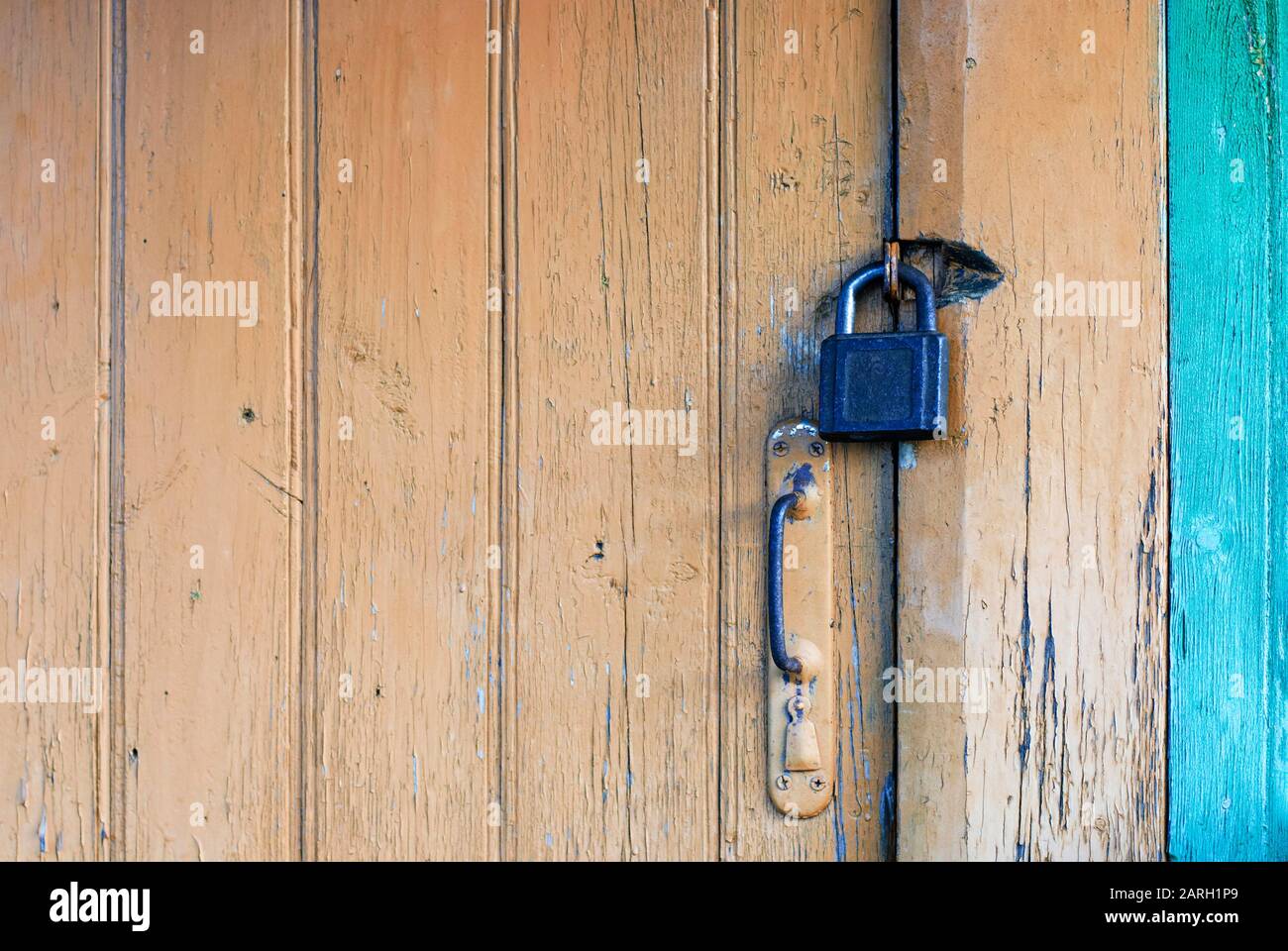 Old closed door with padlock and knob Stock Photo