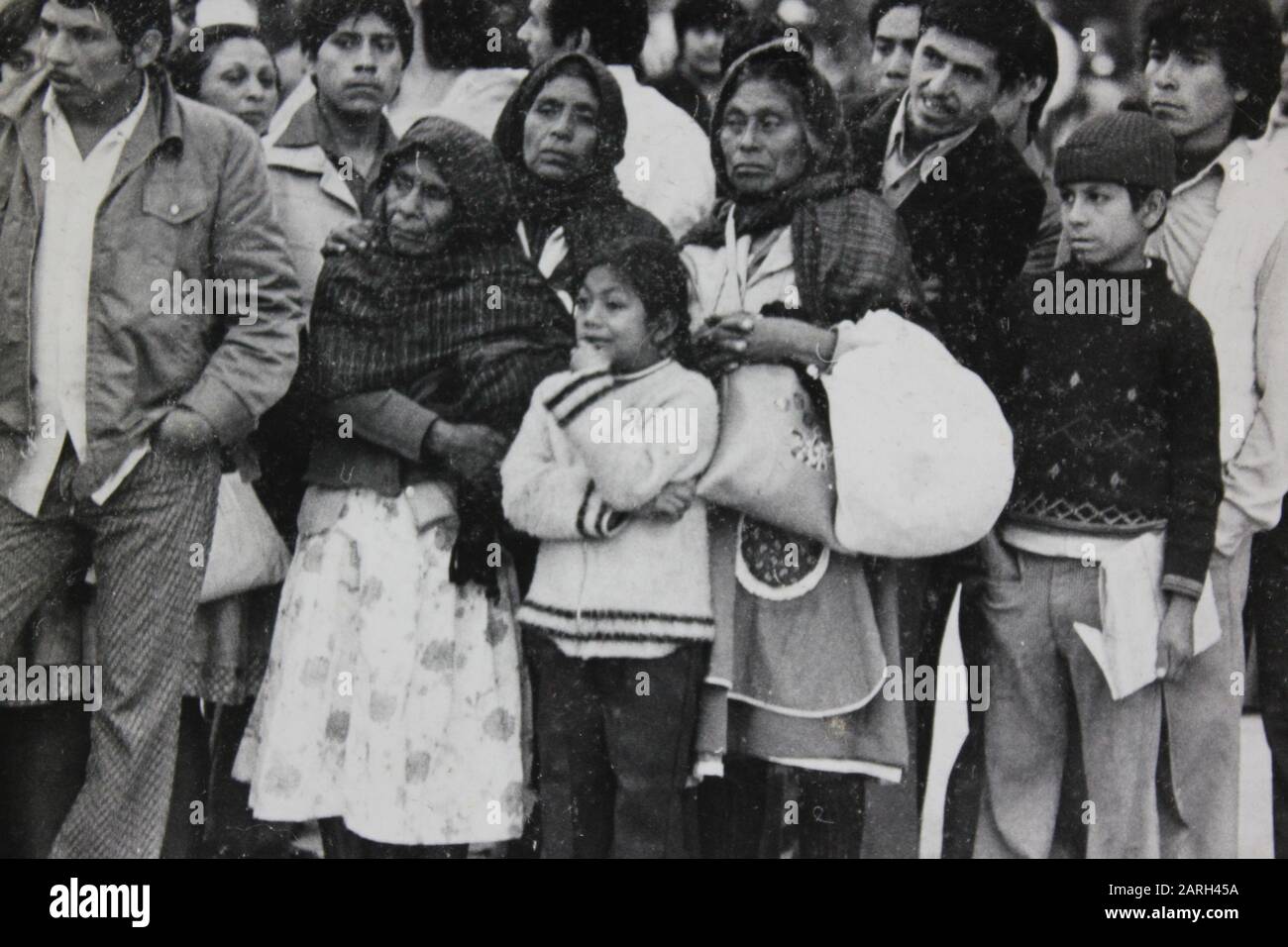 Fine 1970s black and white vintage photography of a group of Mexican people standing and watching Stock Photo