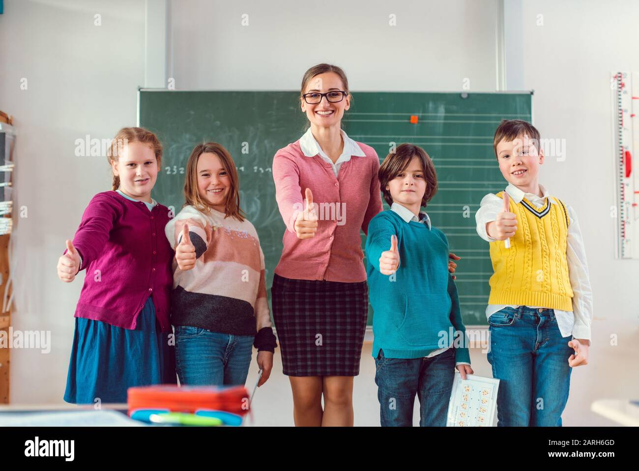 Thumbs up given by pupils and teacher because school is great Stock Photo