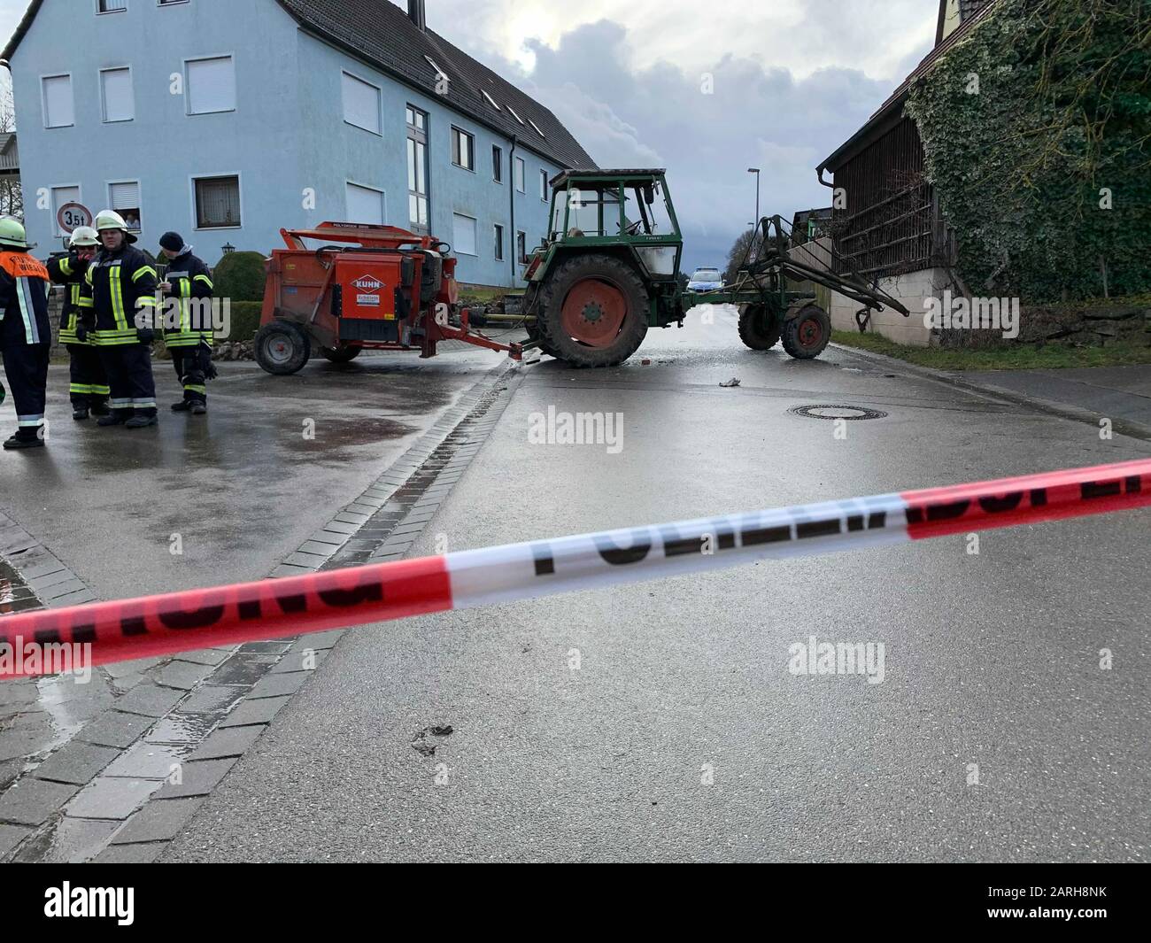 Wieseth, Germany. 28th Jan, 2020. An agricultural tractor stands behind a police barrier on a road. A psychologically conspicuous farmer's son was shot by policemen in the village, after he had first attacked his parents and later officials. Credit: News5/dpa/Alamy Live News Stock Photo