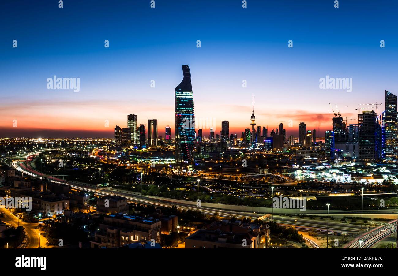 Panorama at dusk showing Kuwait city skyline buildings and ring road Stock Photo