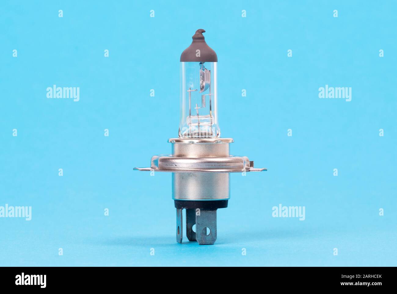 Old light bulb for car headlights isolated on blue background Stock Photo