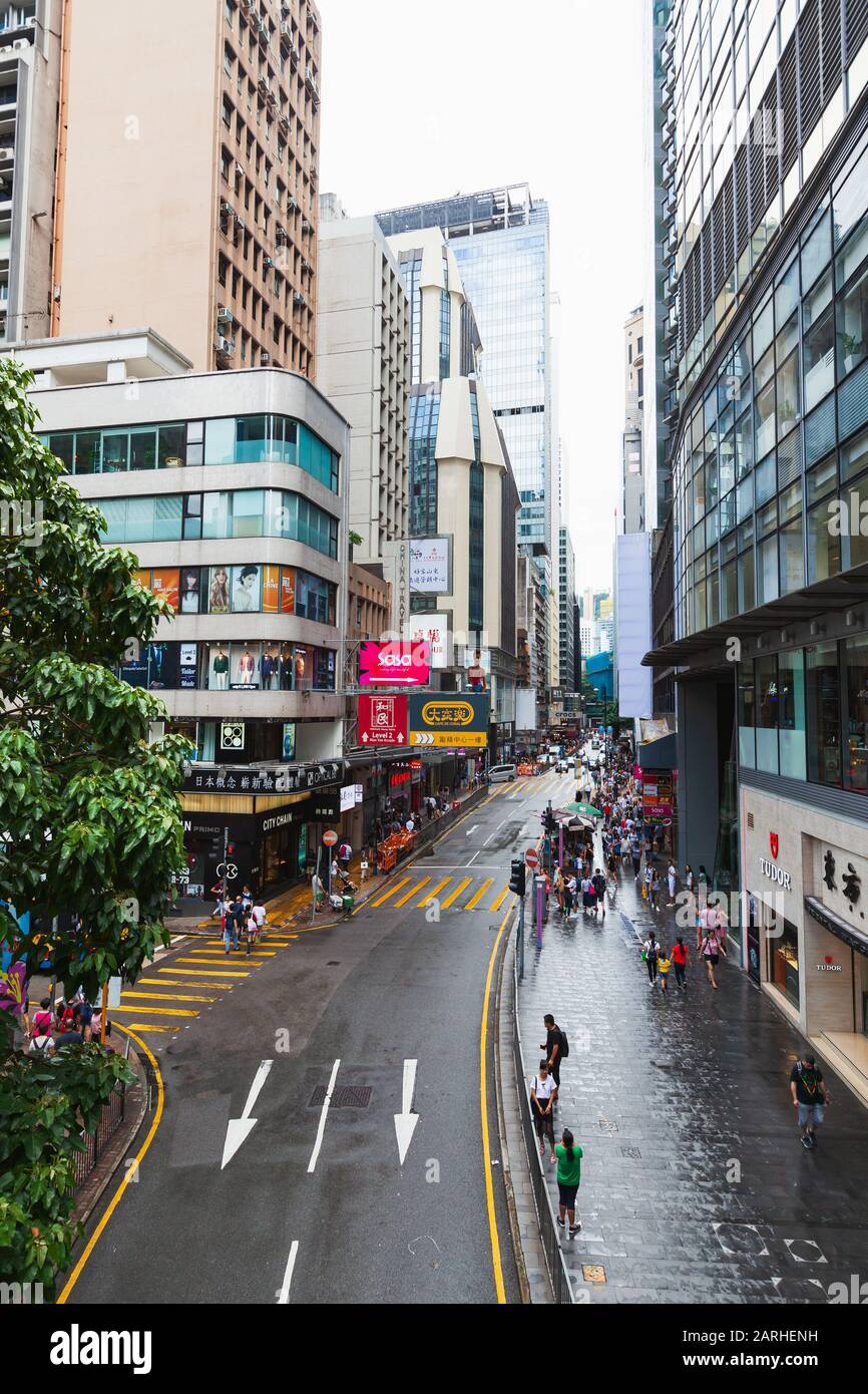 Hong Kong - July 15, 2017: Perspective street view of Central District, Hong Kong. Ordinary people walk the street. Vertical photo Stock Photo