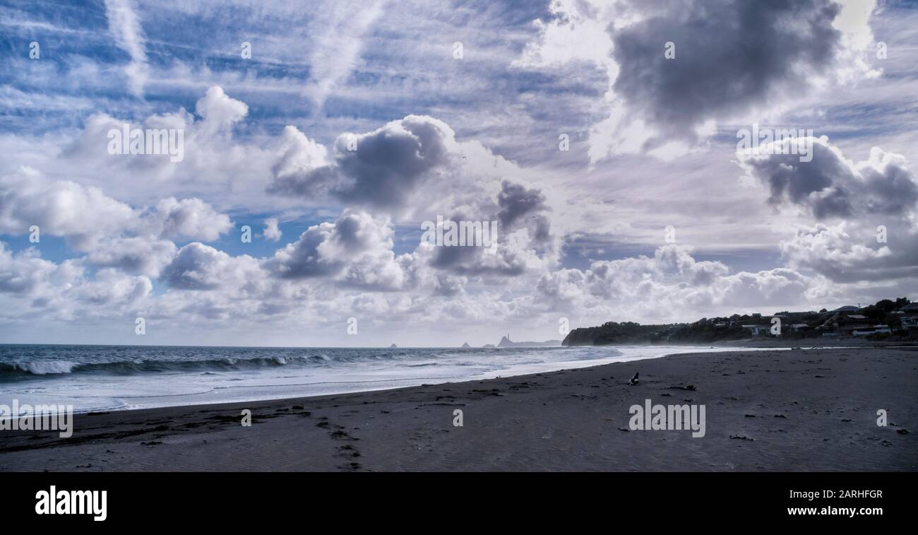 View along Oakura Beach on a bright cloudy day in the Taranaki region of New Zealand Stock Photo