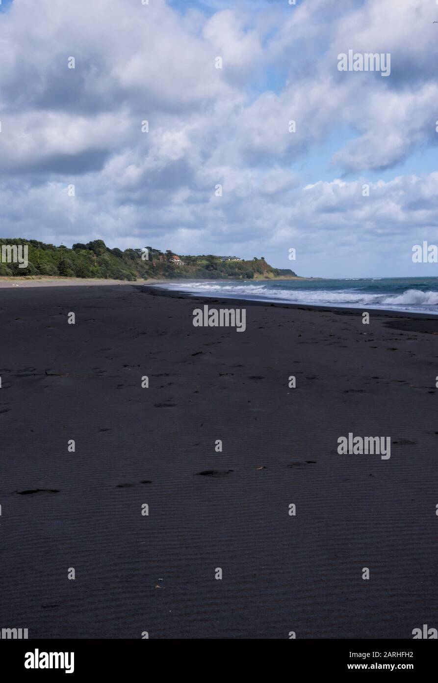 View along Oakura Beach on a bright cloudy day in the Taranaki region of New Zealand Stock Photo