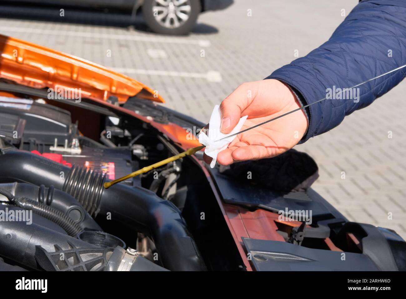 Automobile maintenance concept. Driver checking oil level in car engine dipstick. Close up. Stock Photo