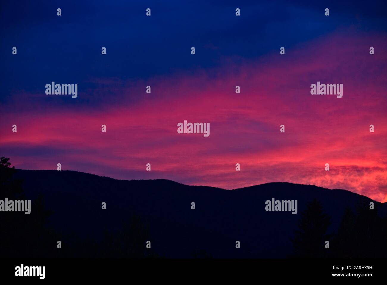 Beautiful, brilliant evening sunset over the Vermont's green mountains Stock Photo