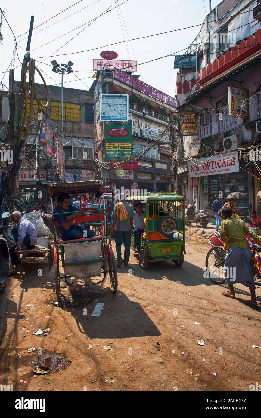 Busy street in Chandni Chowk area of Delhi, with carts, rickshaws, tuk tuk, motorbikes and people Stock Photo