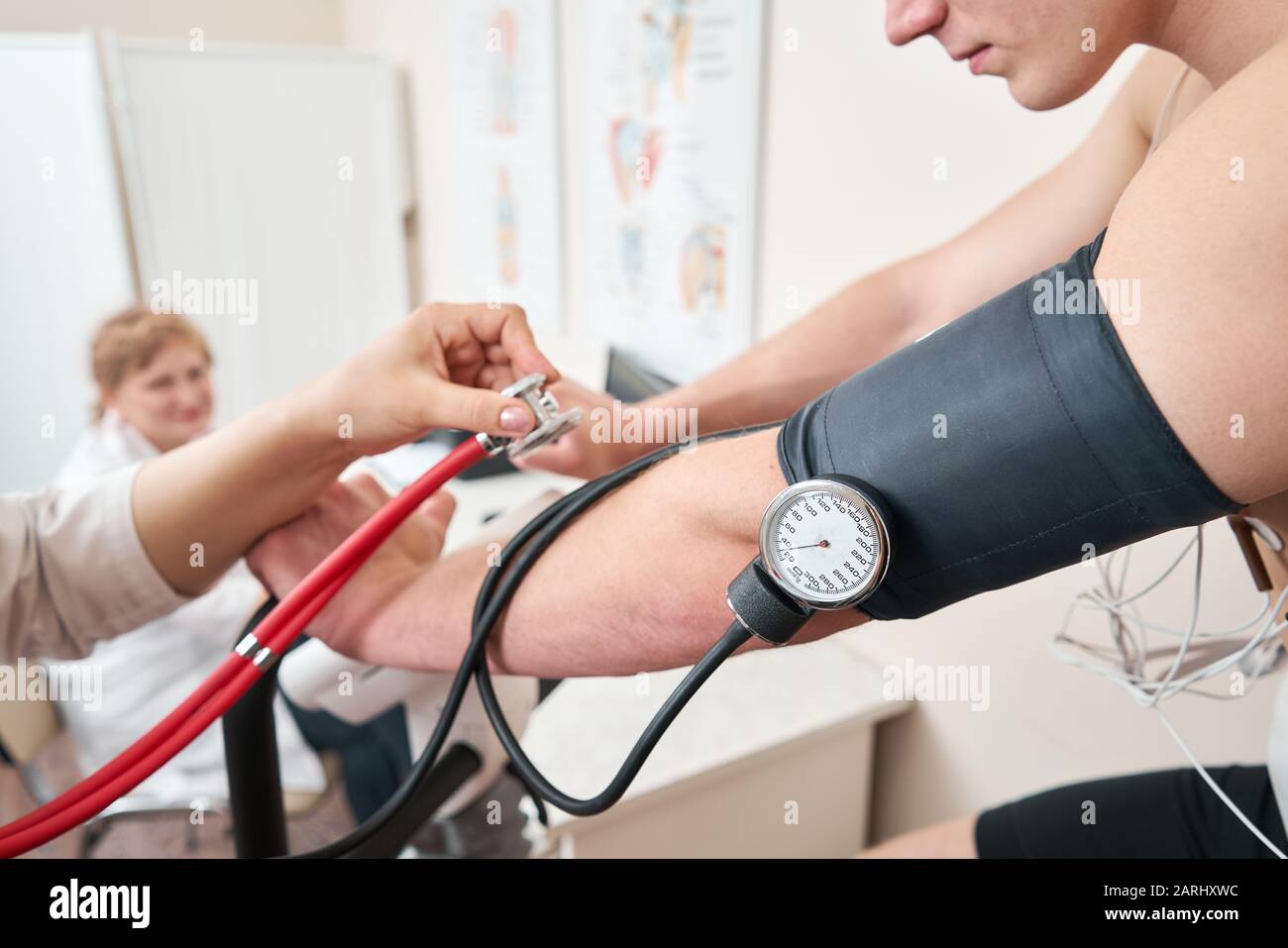 The nurse measures arterial tension. Man patient, pedaling on a bicycle