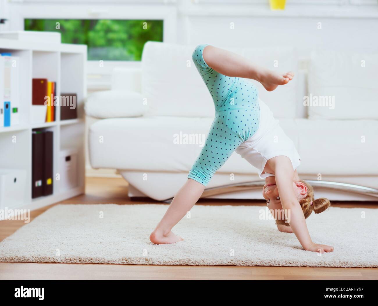 Cute little child girl making morning exercises and yoga at home Stock ...
