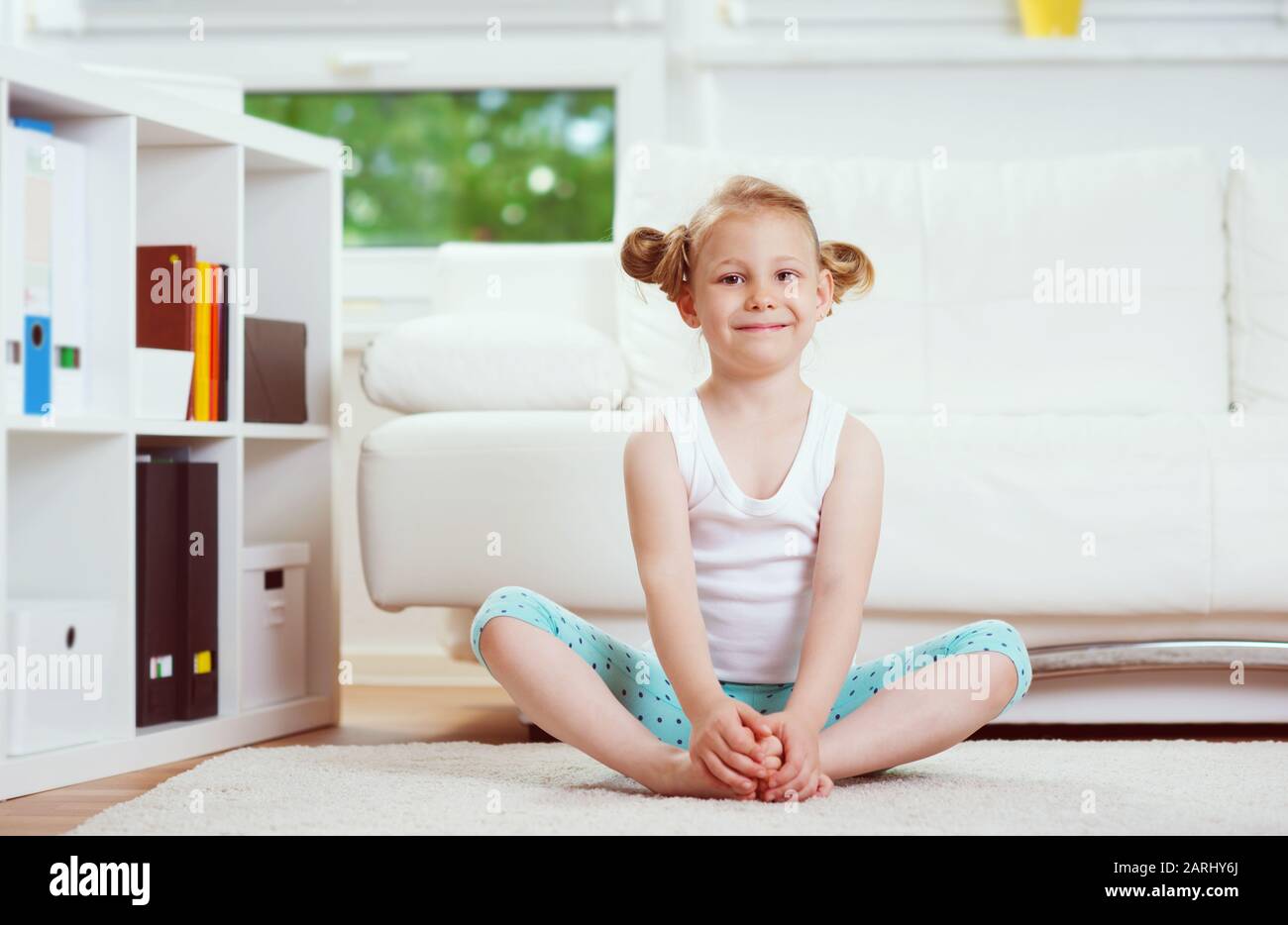 Cute little child girl making morning exercises and yoga at home Stock ...