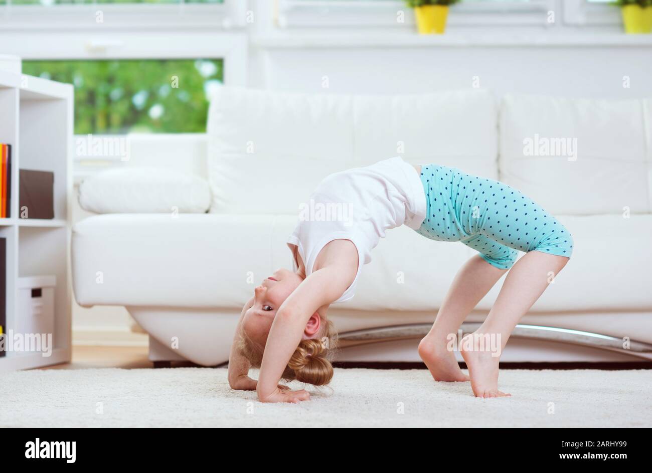 Cute little child girl making morning exercises and yoga at home Stock ...