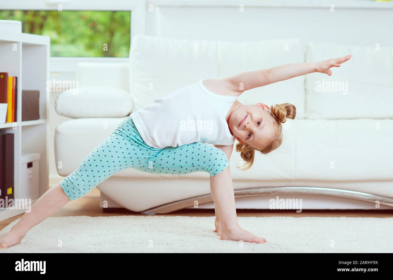Cute little child girl making morning exercises and yoga at home Stock ...